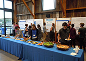 Attendees interacting with research and getting food